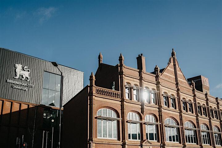 A ground-level photograph of the STEAMhouse building in the foreground at the bottom of the photo, with a blue sky in the background.